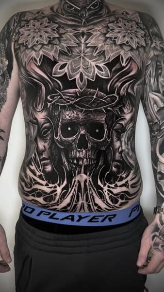 Realism skull and faces tattoo by @ozkotattooart
