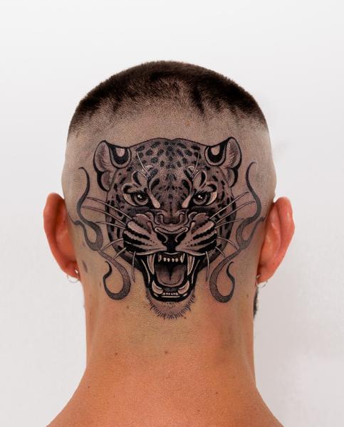 Blackwork leopard head tattoo by @lozzarachtattooer