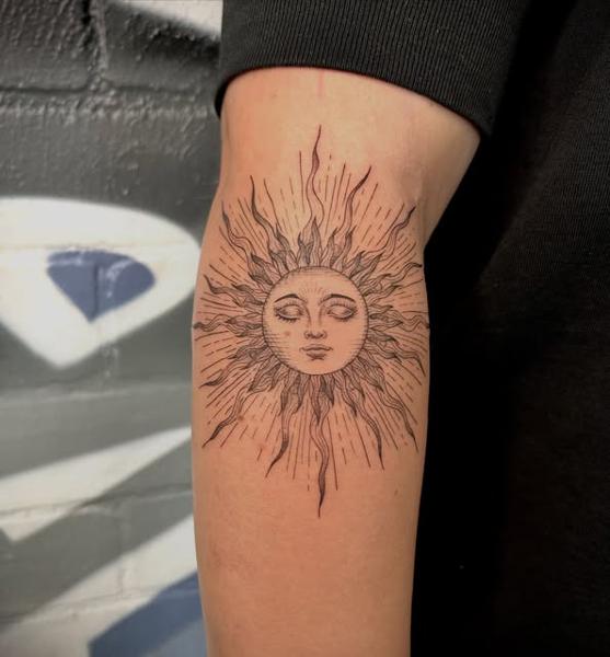 Fine line sun face tattoo by @marcelclaude.tattoo