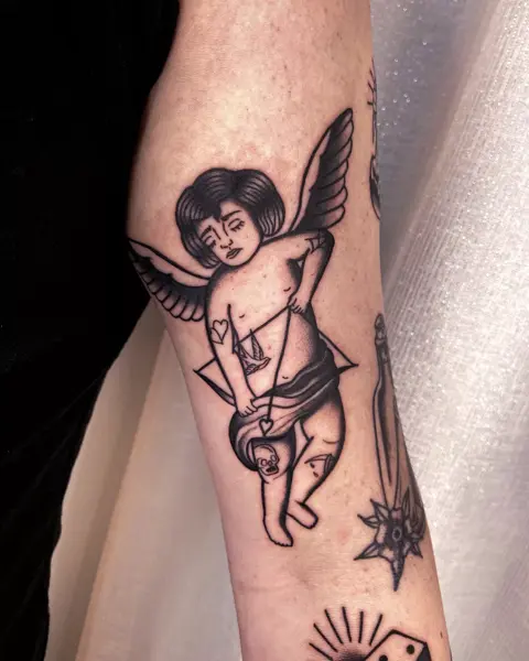 Traditional melancholy cupid tattoo by @marditattoo