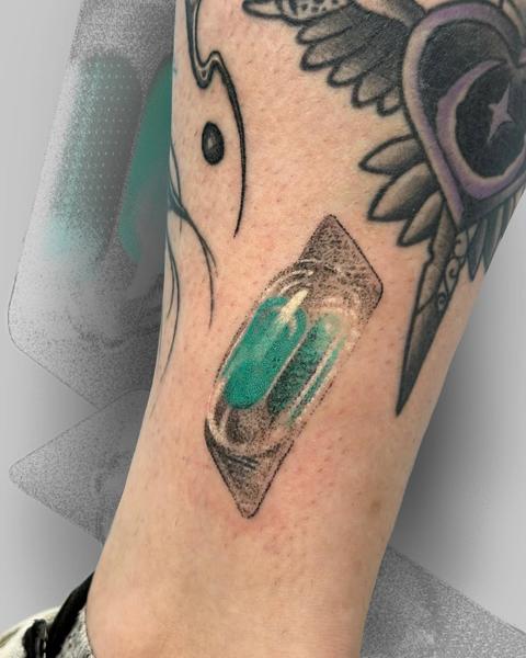 Realism bandage capsule tattoo by @salvidenning_art