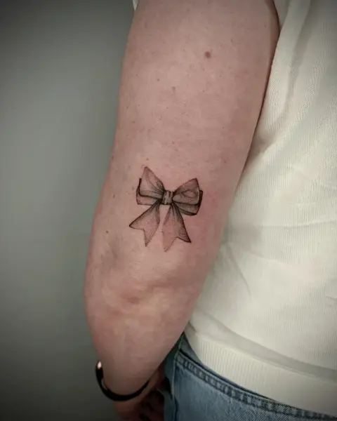 Fine line dotwork delicate bow tattoo by @martatattoos