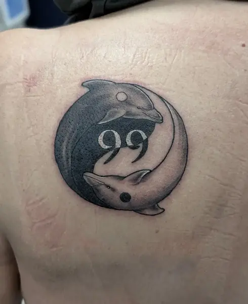 Black and grey yin-yang dolphins tattoo by @fearn_tattoo