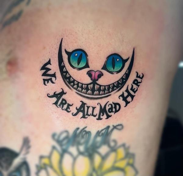 Illustrative cheshire cat grin tattoo by @meg.tattz