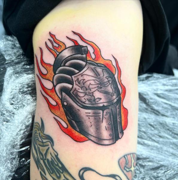 Traditional flaming helmet tattoo by @mikotattoo