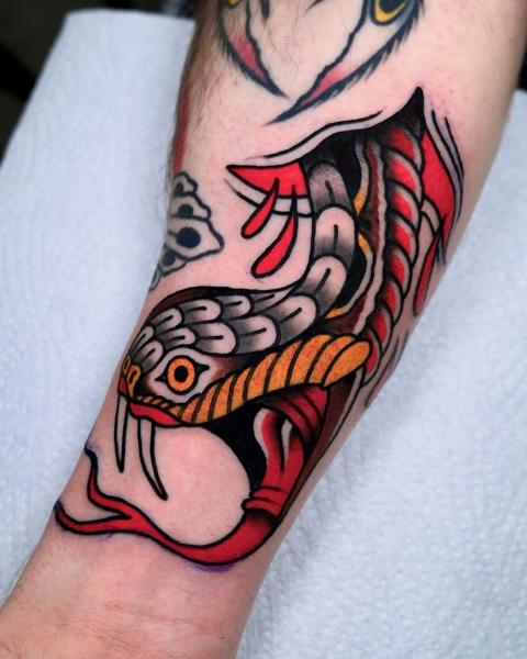 Traditional snake head tattoo by @morstattoo