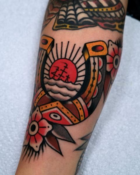 Traditional horseshoe and flower tattoo by @morstattoo