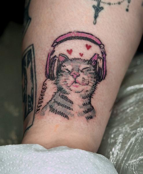 Illustrative cat with headphones tattoo by @nstia.tatts