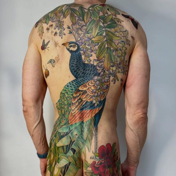 Realism peacock and foliage tattoo by @nikole_lowe