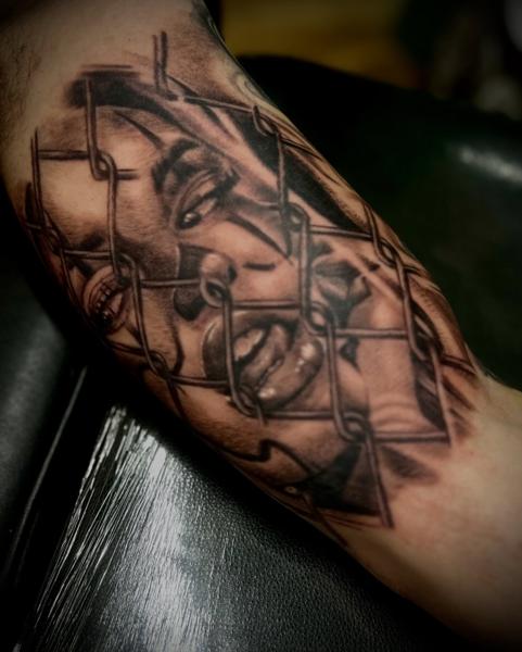 Realism face behind fence tattoo by @nikosrodis