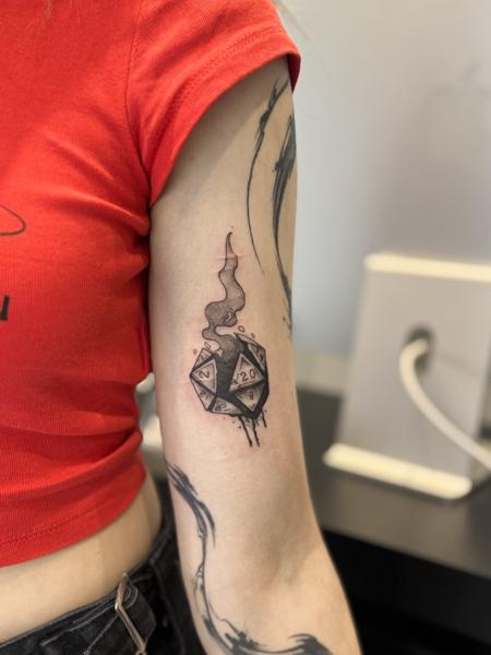 Blackwork smoking d20 dice tattoo by @kristeake.tattoo
