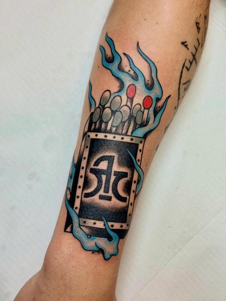 Traditional flaming matchbox tattoo by @panikas_tattooer