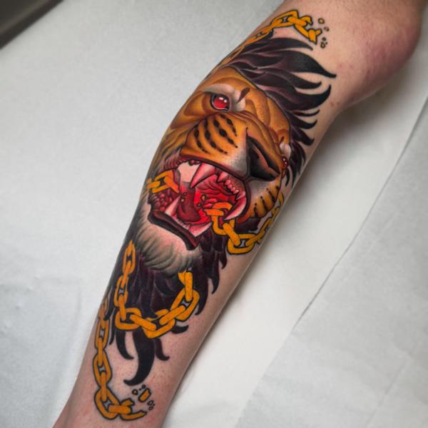 Traditional lion with chain tattoo by @petermurrayartist