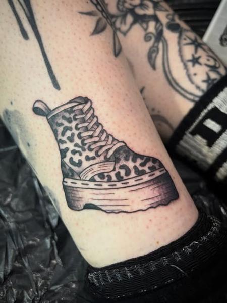 Traditional leopard print boot tattoo by @poppyoliviatattoo