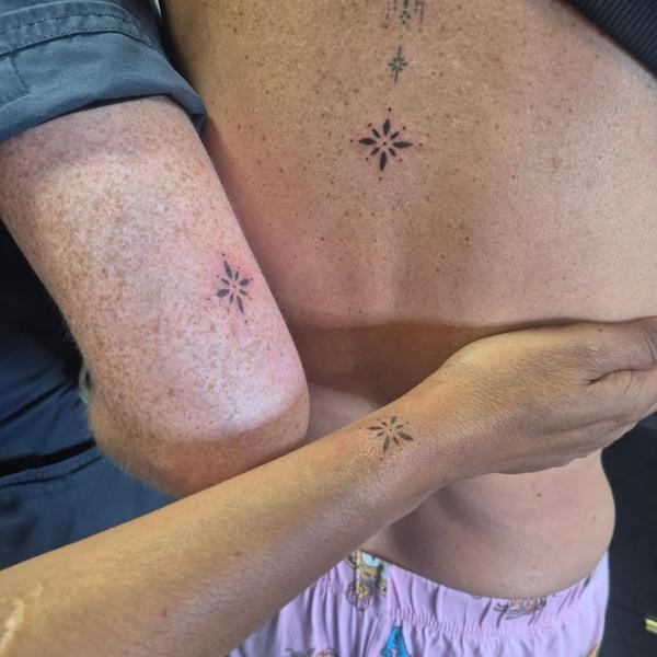 Fine line starburst tattoo by @rachaelmarie.floraink