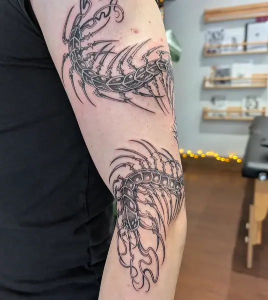 Blackwork centipede tattoo by @inkleigh.tattoo