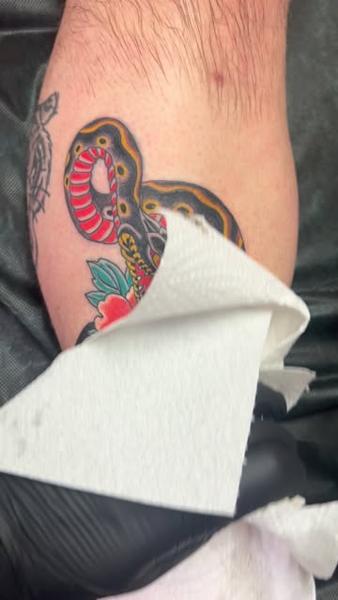 Traditional floral snake tattoo by @richpearson