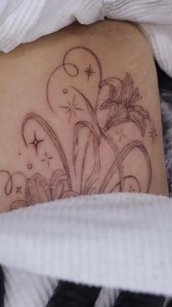 Fine line lily flower sparkles tattoo by @tattooist_rimi