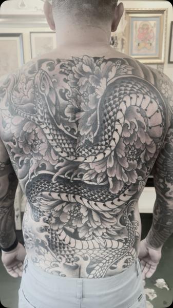 Japanese snake and flowers tattoo by @robertatkinson_tattoo