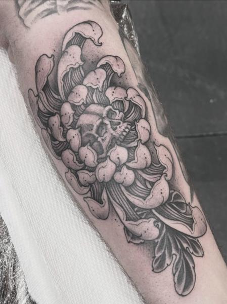 Blackwork skull flower tattoo by @robertatkinson_tattoo