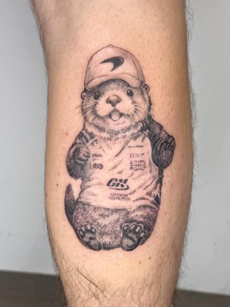 Illustrative otter in cap tattoo by @samclaridgetattoos