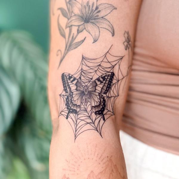 Fine line butterfly on web tattoo by @sasha7tattoos