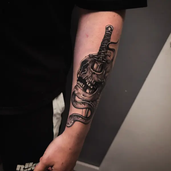 Realism skull and dagger tattoo by @rayne.tattoos