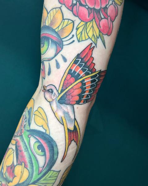 Traditional colorful bird tattoo by @seshi.ink