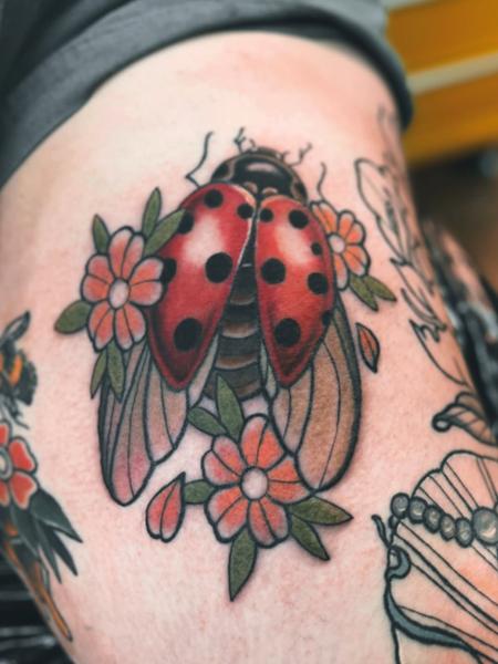 Traditional ladybug flowers tattoo by @shrddr_tattoo