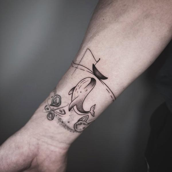 Illustrative whale and boat tattoo by @delavina.ttt