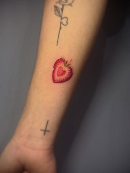 Realism strawberry heart tattoo by @delina_st_tattoo