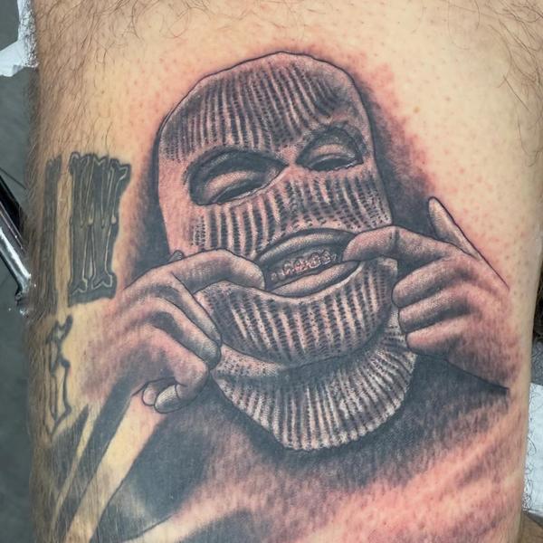 Realism masked figure tattoo by @tattoozbysteve