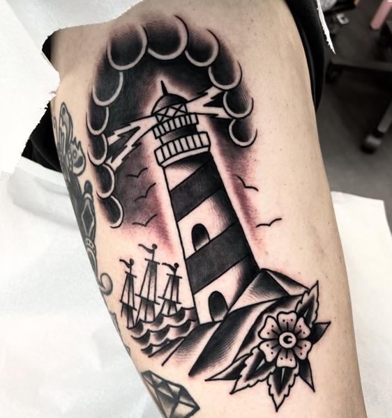Traditional lighthouse scene tattoo by @stoyjunx
