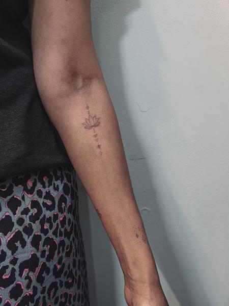 Fine line lotus flower tattoo by @terrie_titouutattoo
