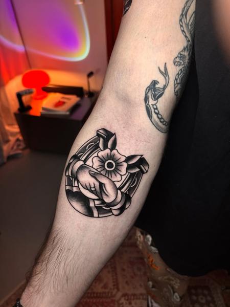 Traditional horseshoe hand flower tattoo by @broy_tattooer