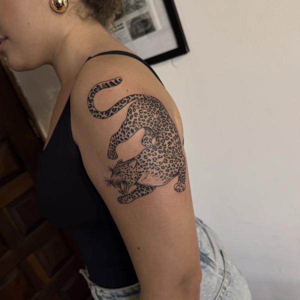 Blackwork crouching leopard tattoo by @titotattooart_