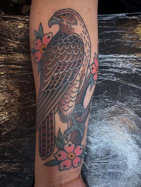 Traditional hawk and flowers tattoo by @wolfslayertattoos