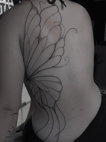 Illustrative blackwork stylized wing tattoo by @yasart.tattoo